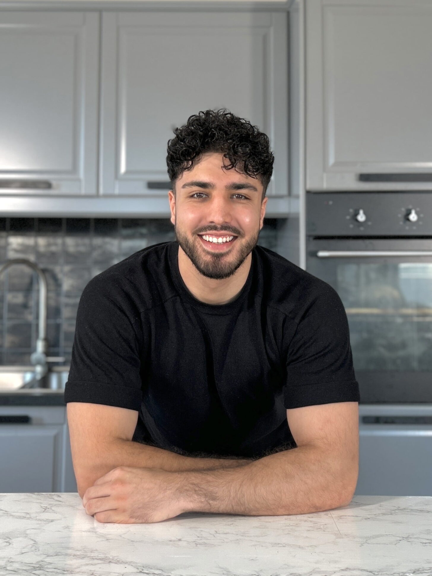 Profile Picture of Ahmad Noori (Dr. Vegan) in front of his kitchen