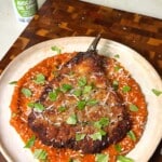 Golden panko-crusted fried eggplant cut open to show the tender interior over roasted tomato marinara