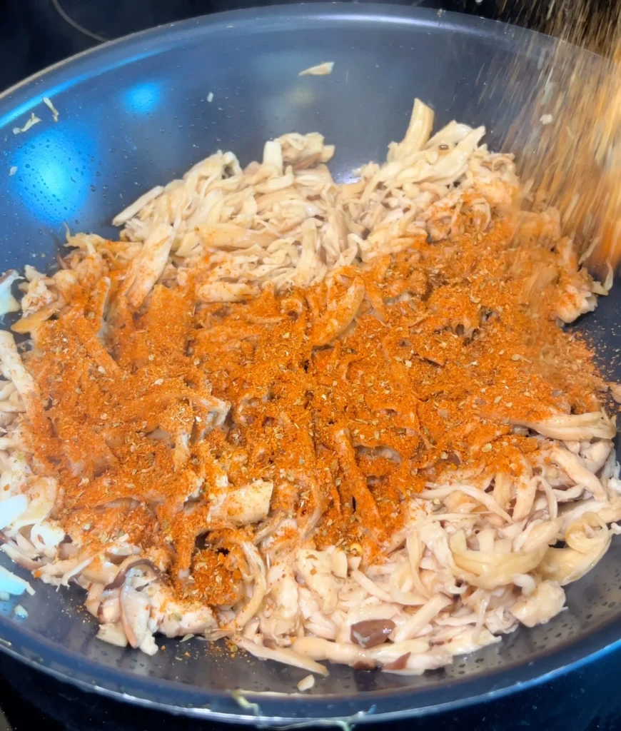 Adding seasoning mix to crispy king oyster mushrooms