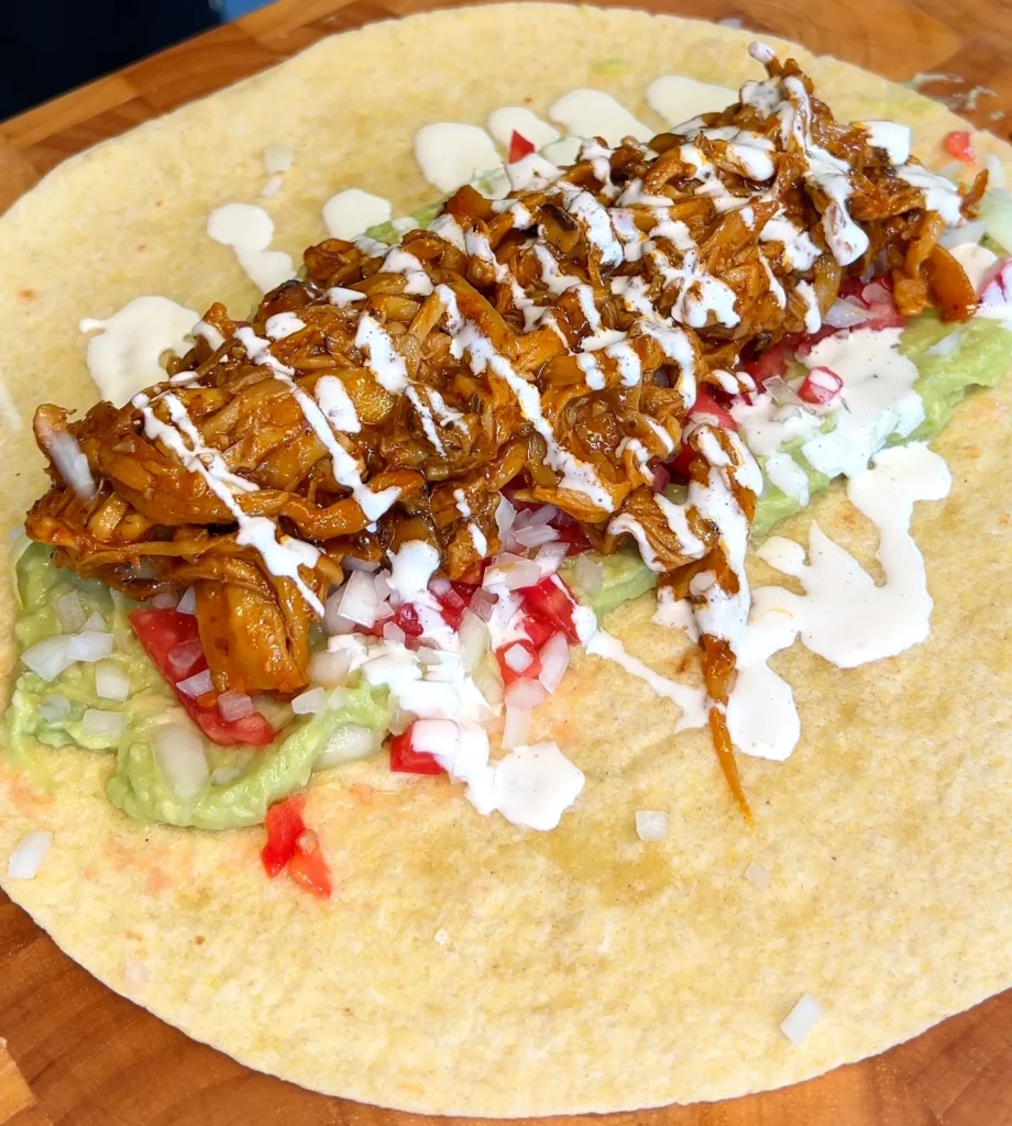 Adding fresh veggies to a vegan mushroom burrito