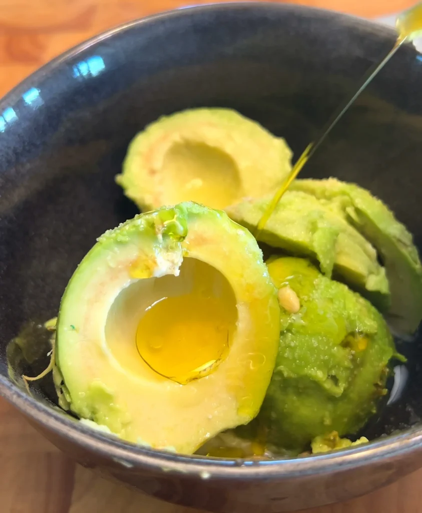 Mashing avocados in a bowl for avocado sauce