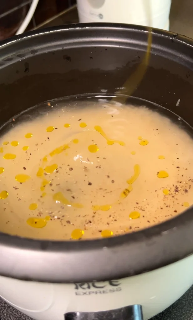 Cooking rice with water and oil in a rice cooker.