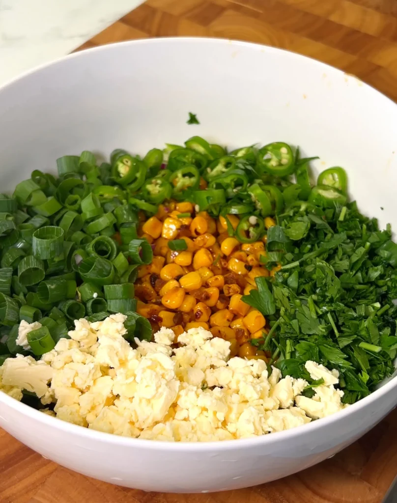 Fresh ingredients for corn salad in a white bowl