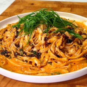 Pouring hot water into a mixture of spices, herbs, and soy sauce for a spicy Asian noodle sauce.