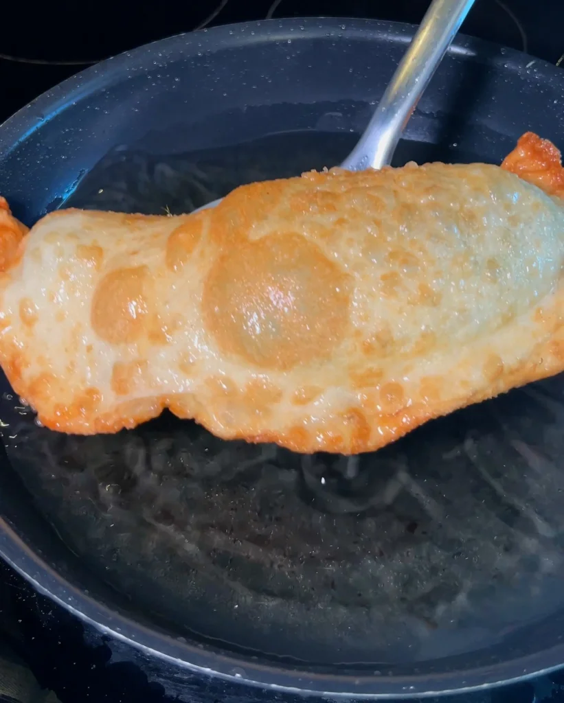 Golden brown fried empanada fresh out of the oil