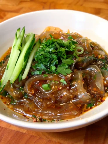 picy glass noodles in chili oil topped with fresh cucumber and parsley