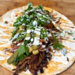 Spreading the sauce on flatbread, add the roasted mushrooms, and load up with your favorite toppings like onions, tomatoes, and pickles.