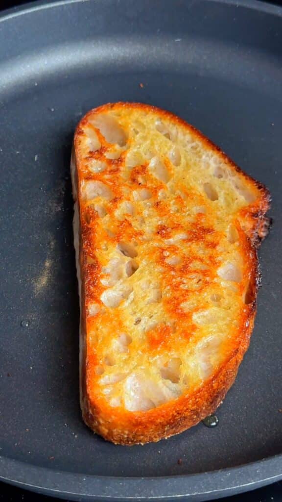 Toast your bread: Slice sourdough at an angle, brush with olive oil, and toast until golden.