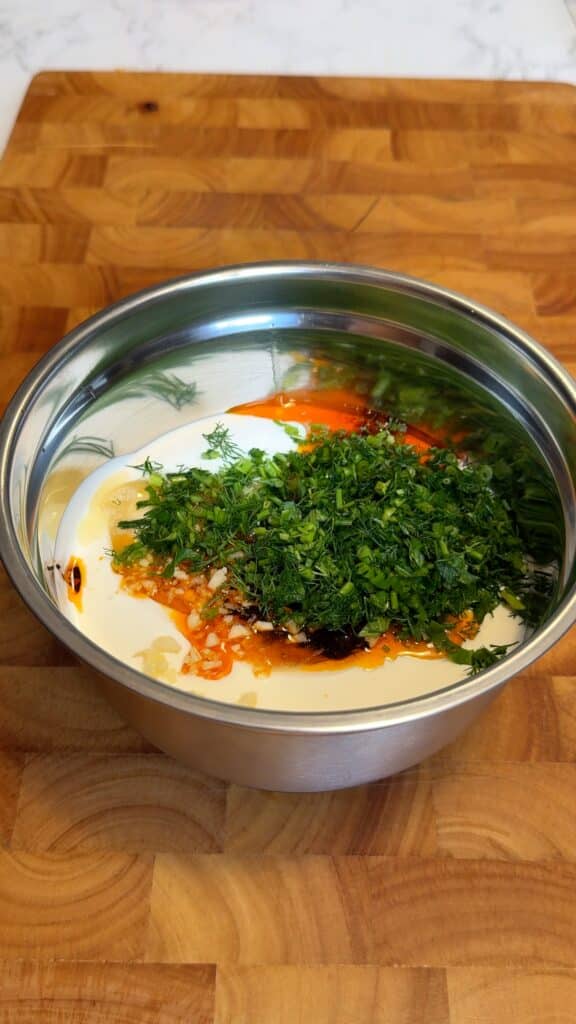 Whisk together vegan yogurt, tahini, chili oil, garlic, parsley, and lemon juice