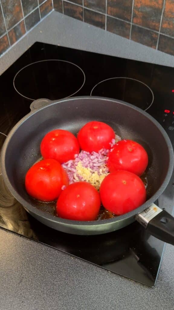 Cook tomatoes, onion, and garlic together until softened and aromatic