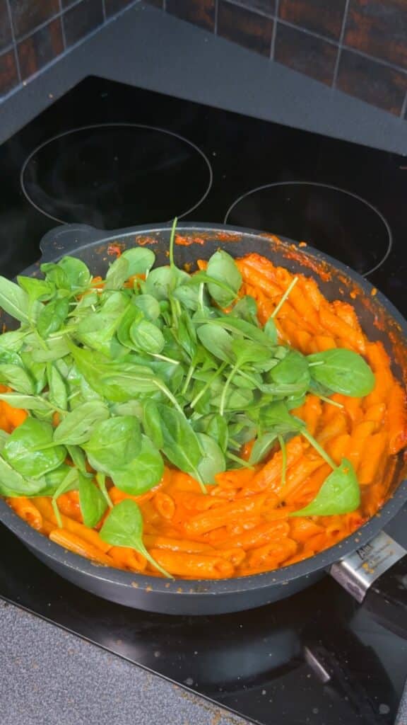 Toss pasta in sauce with spinach and basil until just wilted