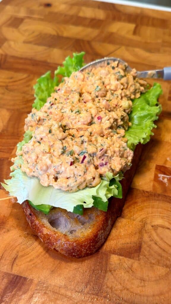 Toast bread and prep fresh toppings like avocado, tomato, or lettuce.