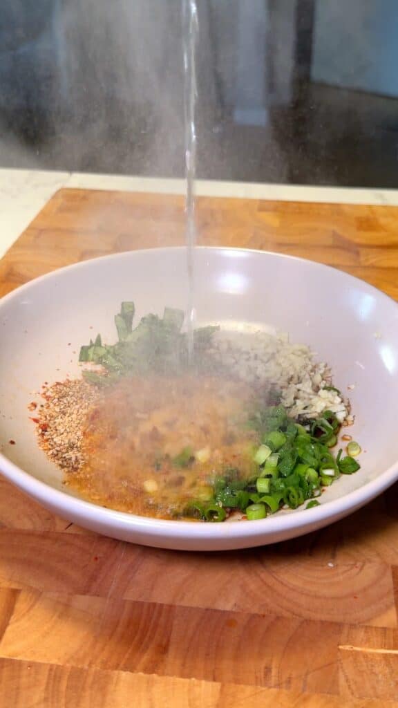 Pour Hot Oil
 Carefully pour hot oil over the mixture to release the flavors. Stir well to create the chili oil sauce.