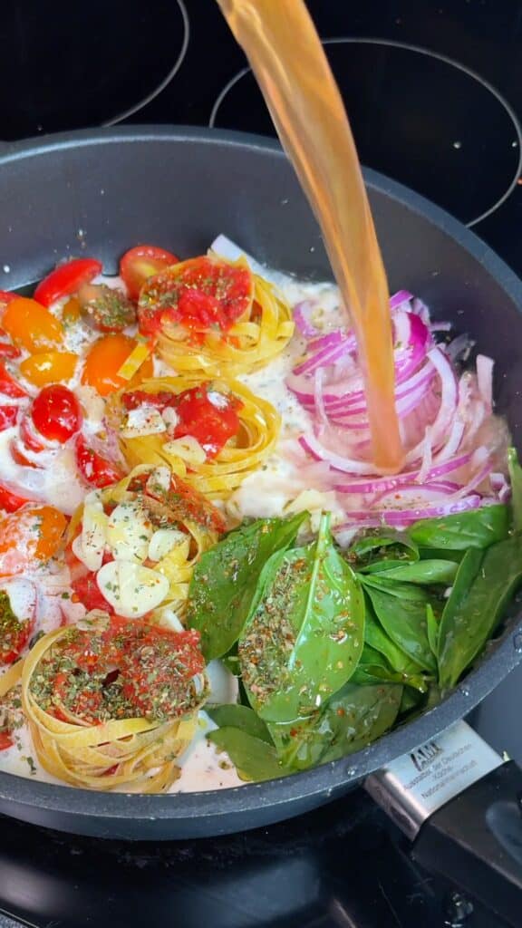 Pour liquids – Add the cream and vegetable broth so the pasta is mostly covered.
