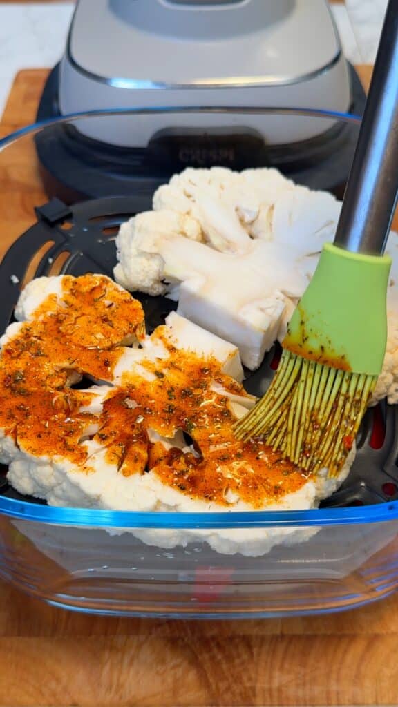 Season the cauliflower: Mix olive oil, paprika, cumin, turmeric, salt, and pepper. Brush onto both sides of the cauliflower steaks.