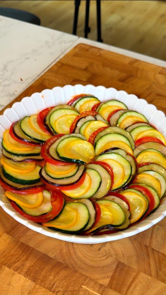 Arrange
Layer them alternately in a spiral pattern over the sauce, slightly overlapping each slice.