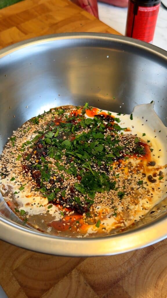 Make the dressing: Whisk together vegan yogurt, vegan mayo, soy sauce, chili crisp, sesame seeds, and chopped cilantro until creamy.