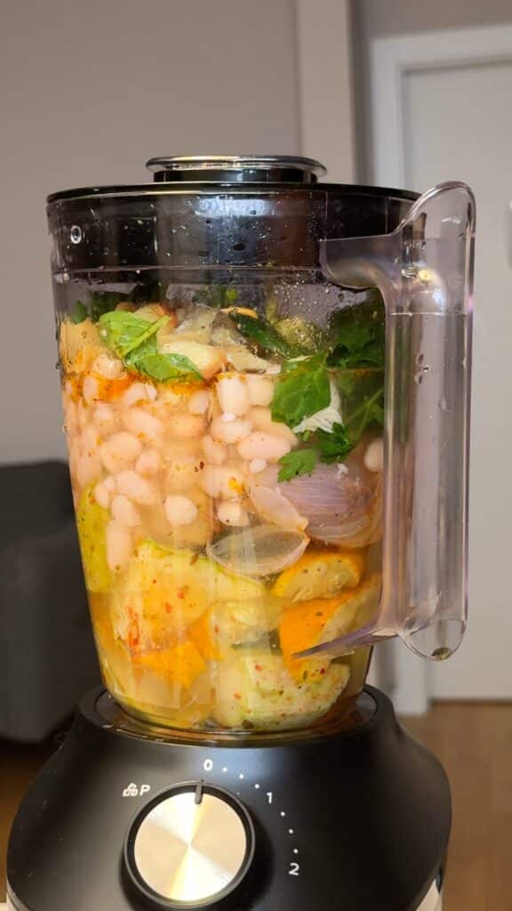 Blend the roasted vegetables with beans, parsley, and broth.