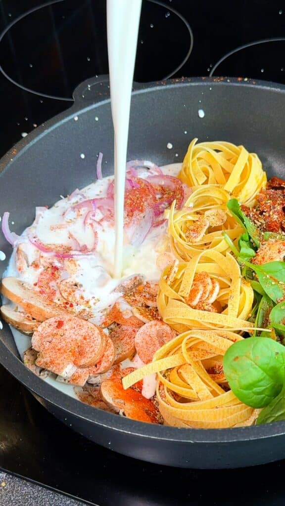 Pour in the liquids and season
Pour in the cream and vegetable stock. Season everything well with Italian seasoning, paprika, salt, and pepper.