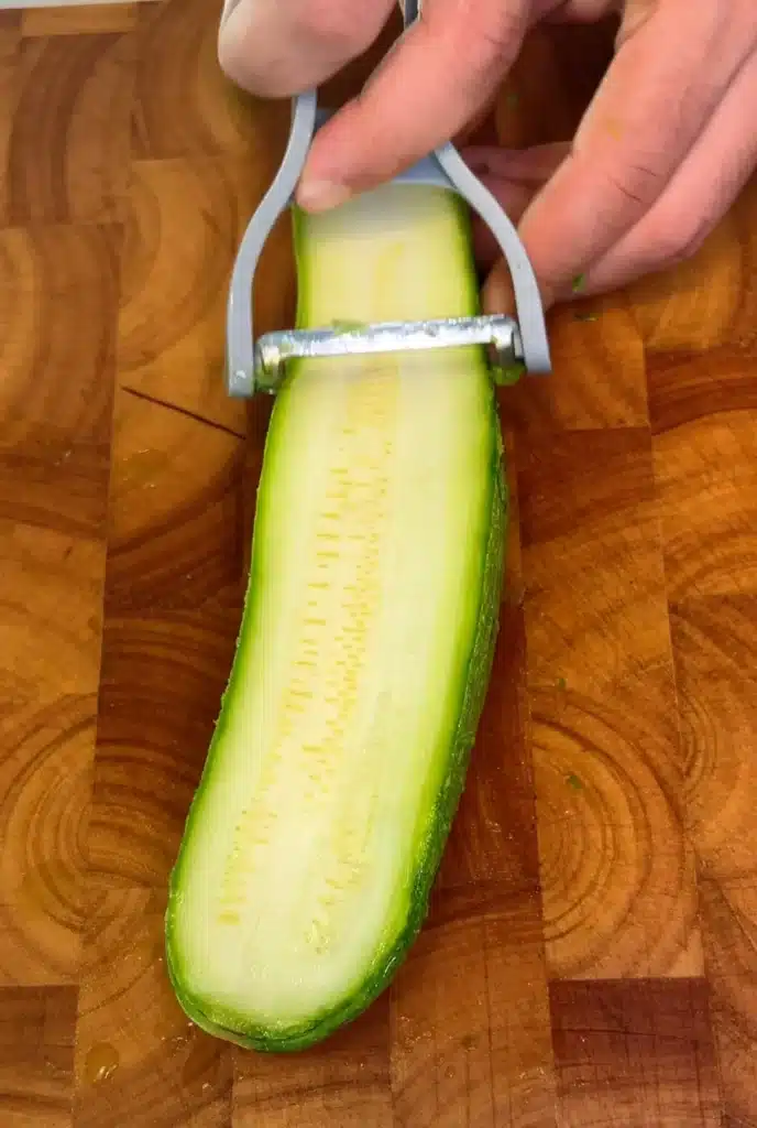 Slice and salt the zucchini
Slice the zucchini lengthwise into thin strips, salt lightly, and let them sit to release excess moisture.