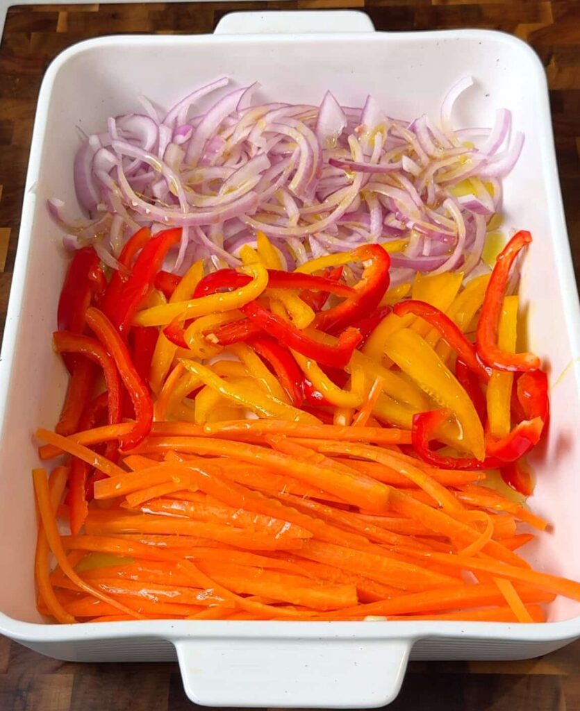 Roast the vegetables Toss the sliced onions, peppers, and carrot with olive oil and salt. Roast until soft and lightly browned.