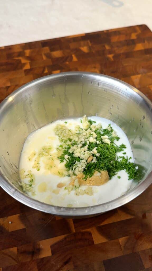 Make the dressing
Whisk together yogurt, mayo, mustard, garlic, dill, lemon, and salt until creamy and smooth.