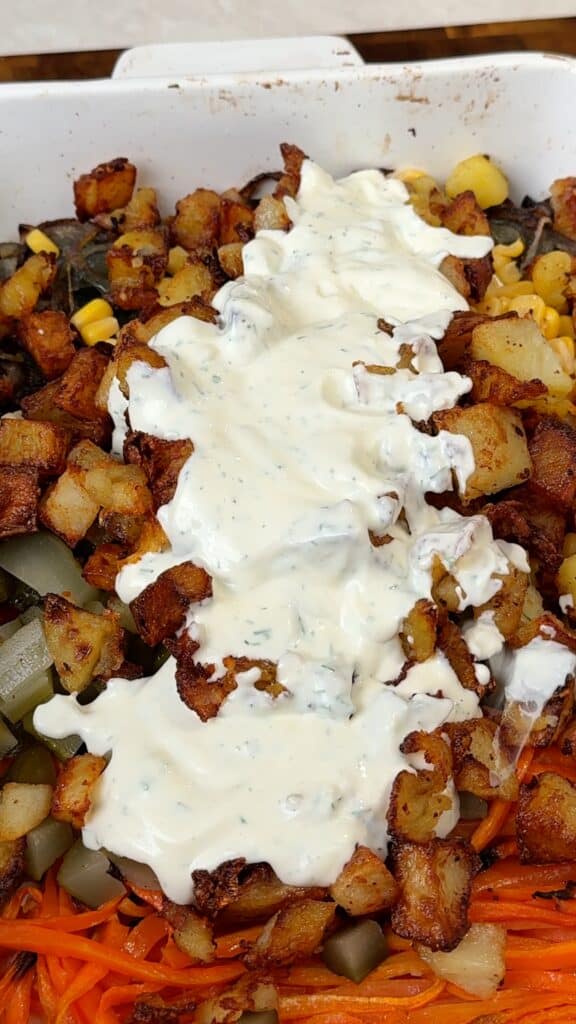 Assemble the salad
Add the roasted vegetables, pickles, and corn to a bowl. Add the warm potatoes, then pour over the dressing and gently toss.