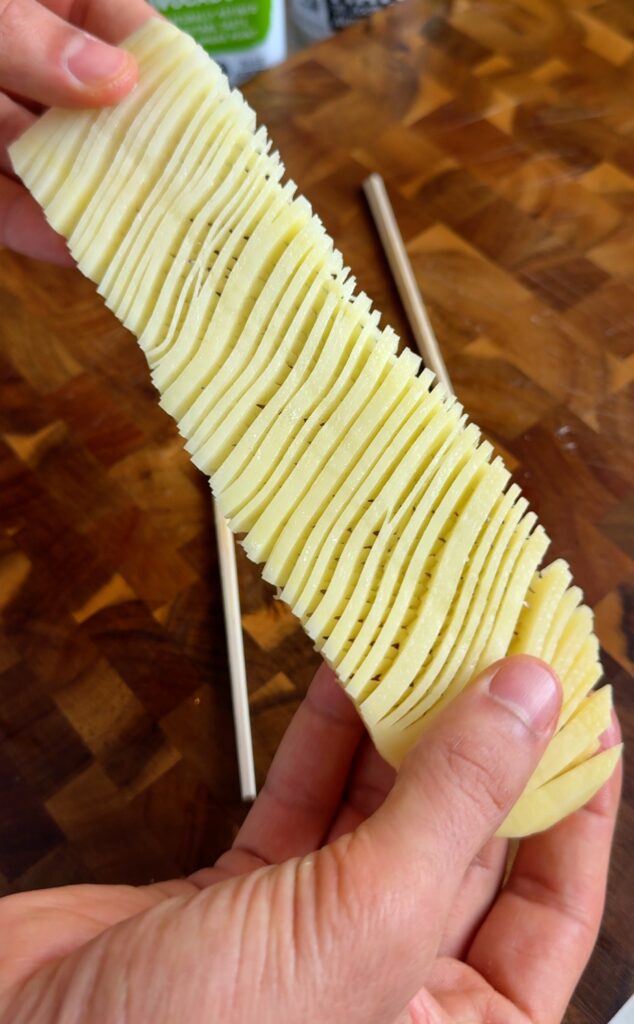 The accordion stretch
Gently flex the plank so it starts to fan open. That’s how you know the cuts are right and it’ll crisp up beautifully.