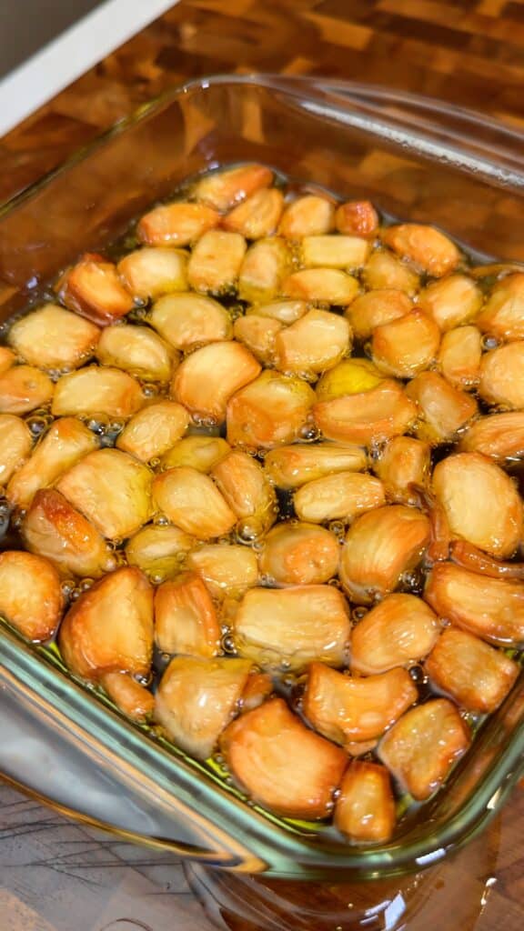 Roast the garlic in oil
Add peeled garlic cloves to a small baking dish, cover with olive oil, and bake gently until the garlic is soft, fragrant, and lightly golden.
