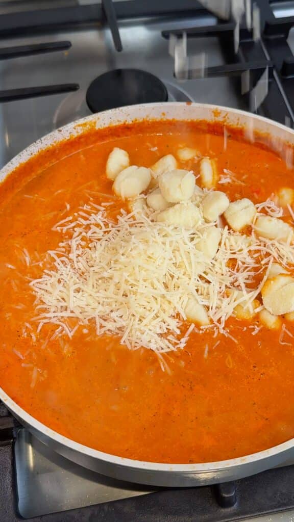Add gnocchi and vegan cheese
Toss in the gnocchi and vegan parmesan. Simmer gently.
