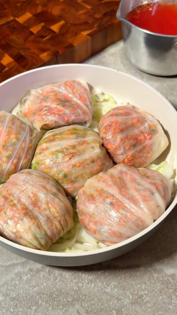 Layer in the dish
Arrange the rolls over a bed of chopped cabbage in your baking dish so they sit snugly together.