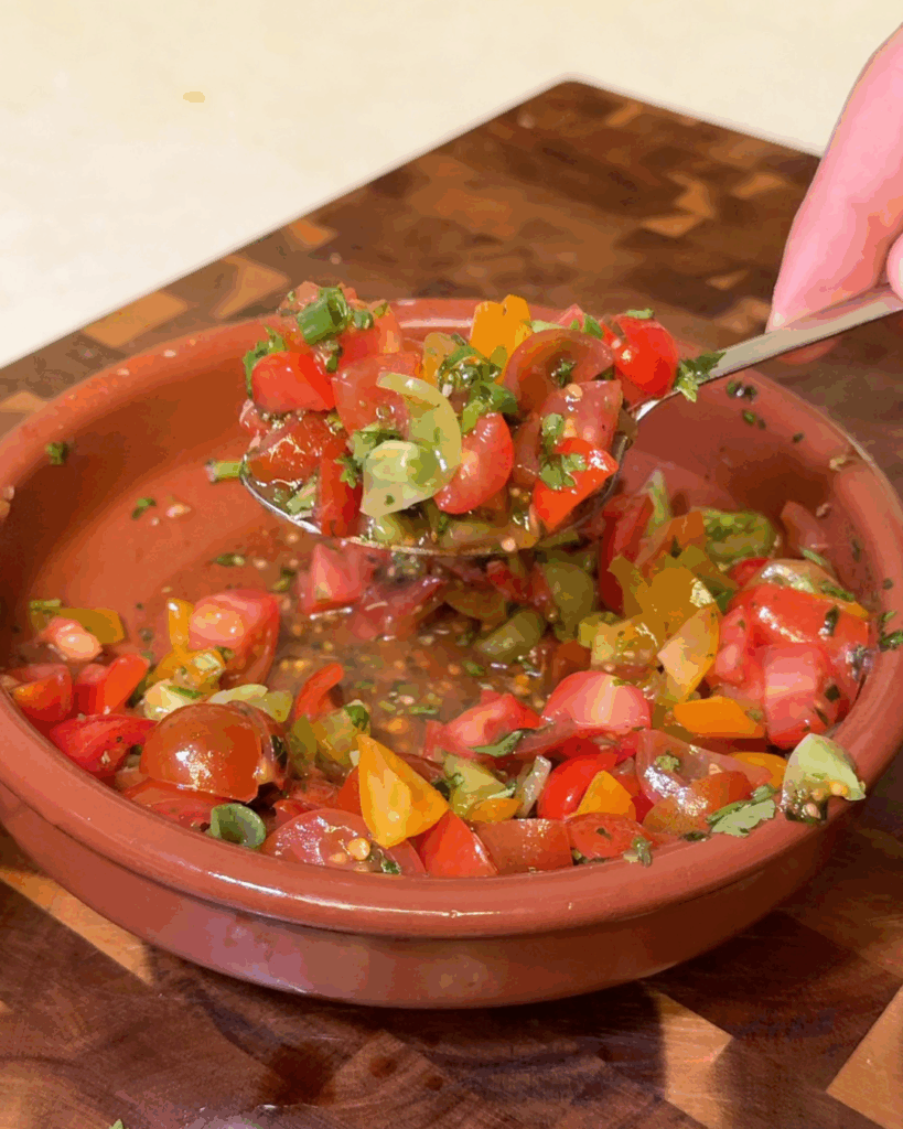 Make the tomato bruschetta
Toss quartered cherry tomatoes with fresh basil, olive oil, balsamic vinegar, red pepper flakes, and oregano.