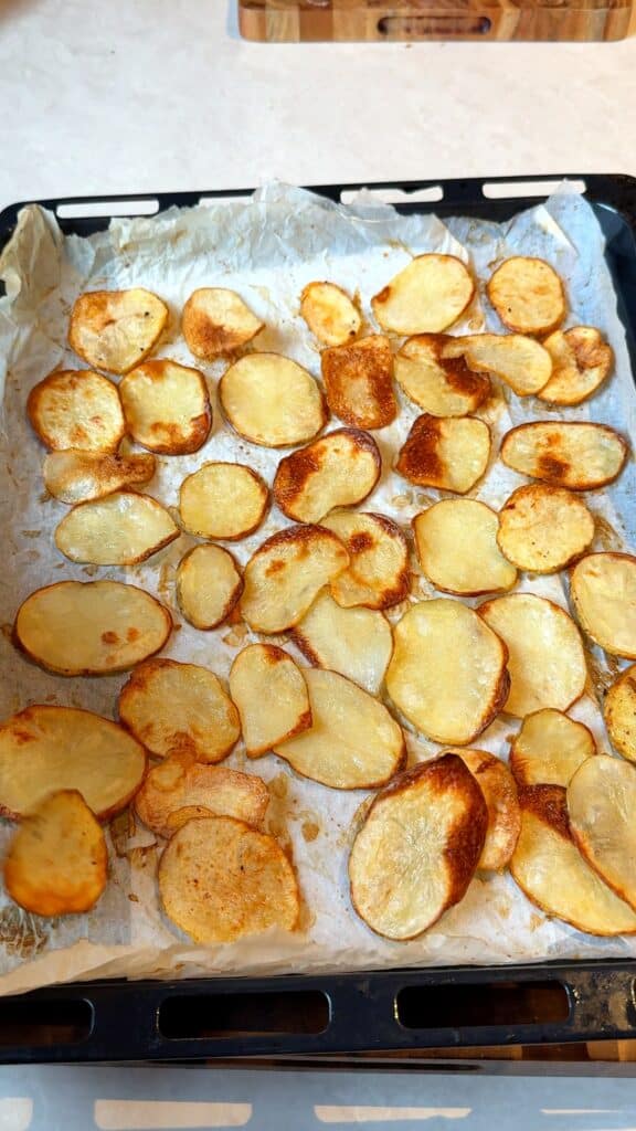 Make the potato chips
Slice russet potatoes paper thin on a mandoline, rinse and soak in cold water, then dry very well. Bake on parchment lined trays until golden and crispy. You can also deep fry or air fry them if you prefer.