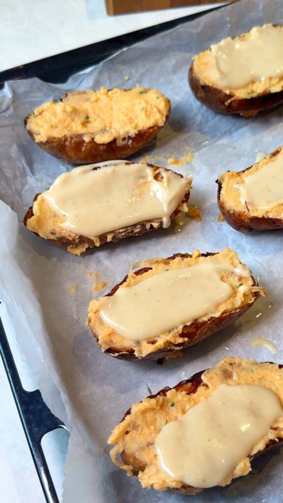 Stuff, top, and bakeFill the shells, drizzle with béchamel, top with vegan cheese, and bake until bubbly and golden.