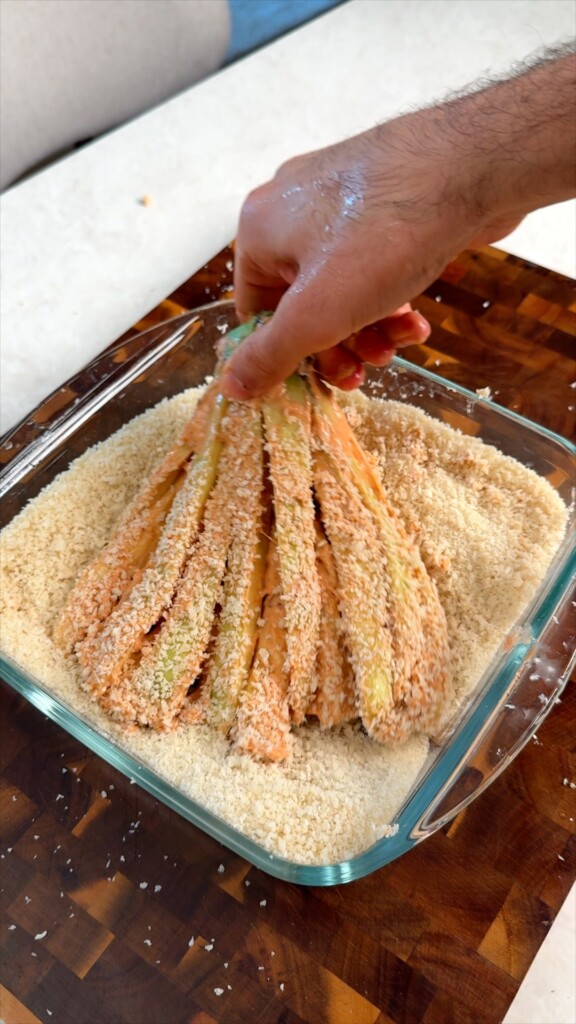 Press into panko While still holding by the stem, press the battered strips into the panko breadcrumbs, turning to coat all sides evenly.