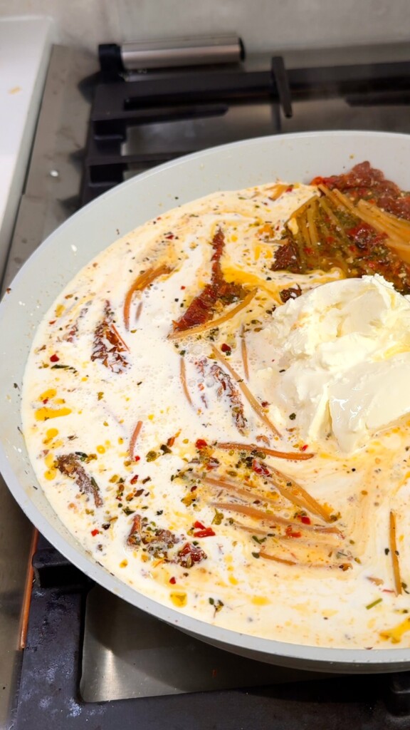 Make it creamy Remove the lid and stir in oat cream, vegan cream cheese, and vegan parmesan. Keep tossing until the sauce thickens and coats every strand.