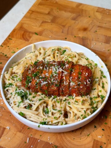 Creamy white bean spaghetti topped with crispy panko tofu and parsley