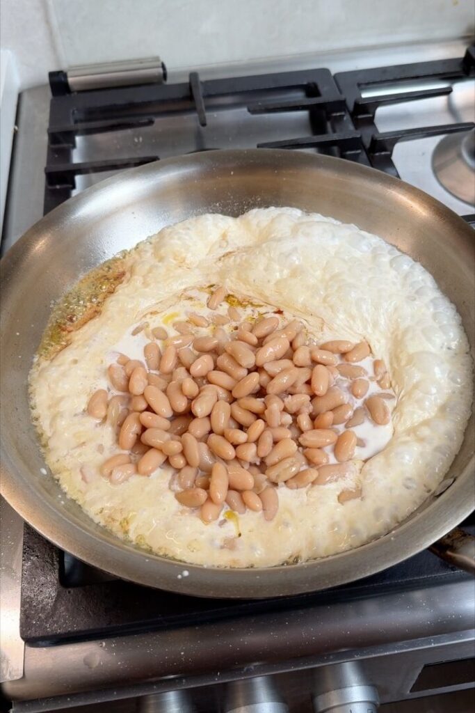 White beans simmering in vegan cream with garlic and chili for creamy pasta sauce