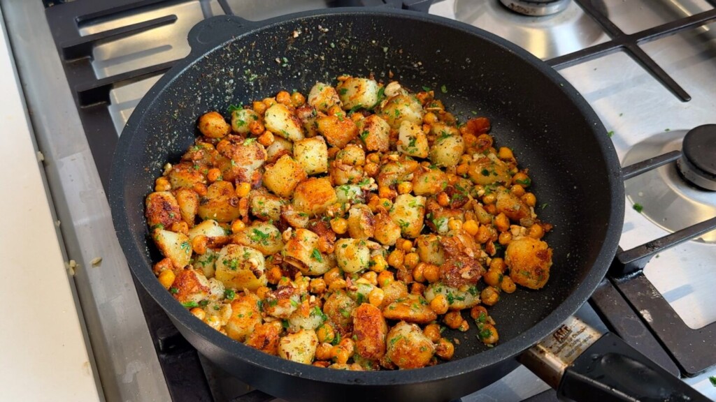 Crispy potatoes and chickpeas tossed with garlic butter, Italian seasoning, and fresh parsley in a skillet