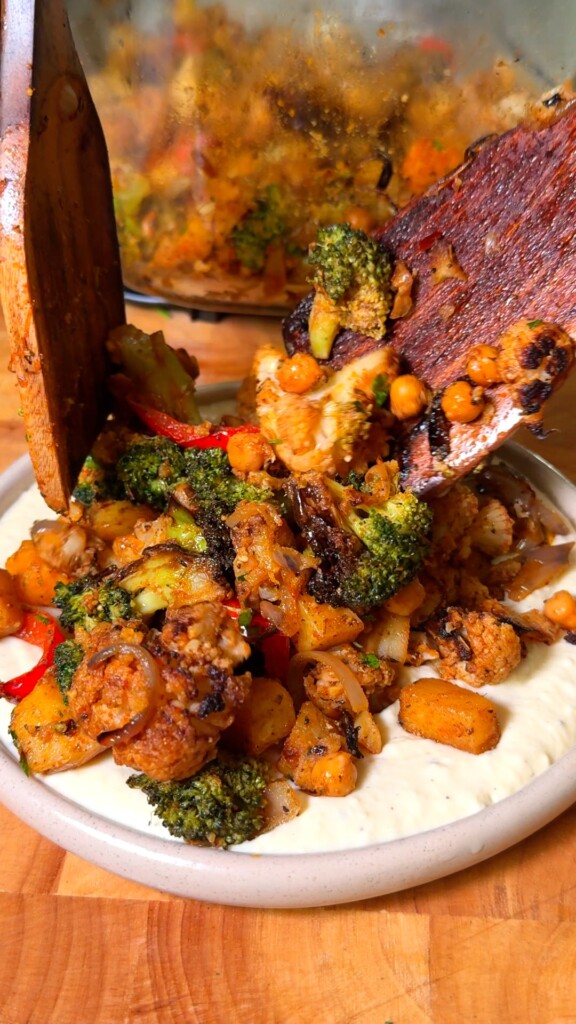 Mediterranean roasted vegetables piled over creamy hummus, finished with parsley and a drizzle of chili crisp
