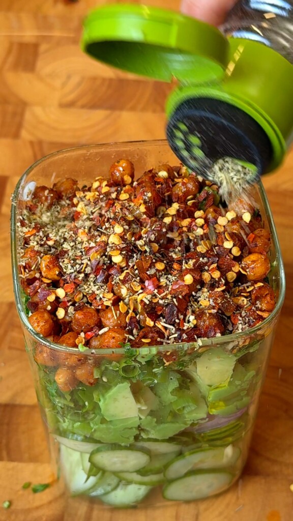 Chili flakes and dried herbs sprinkled over the chickpea cucumber salad