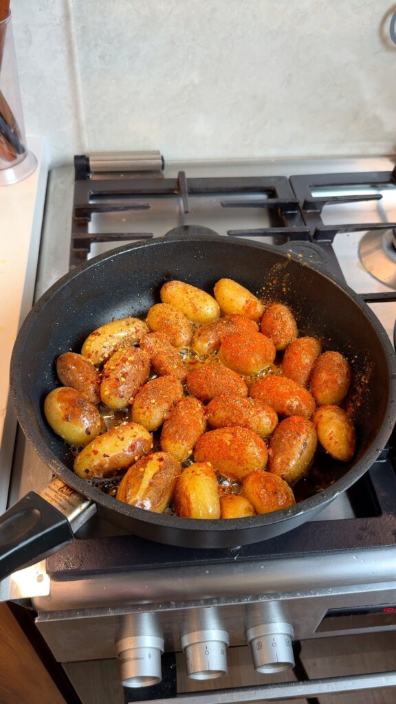 Pan fried baby potatoes dusted with smoked paprika and chili flakes while frying until golden