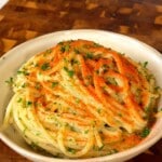 Close-up of blended garlic confit spaghetti twirled in a bowl with a red chili dusting