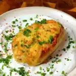 Vegan loaded baked potato stuffed with lentils and tofu, topped with melted vegan cheese and served over garlicky yogurt