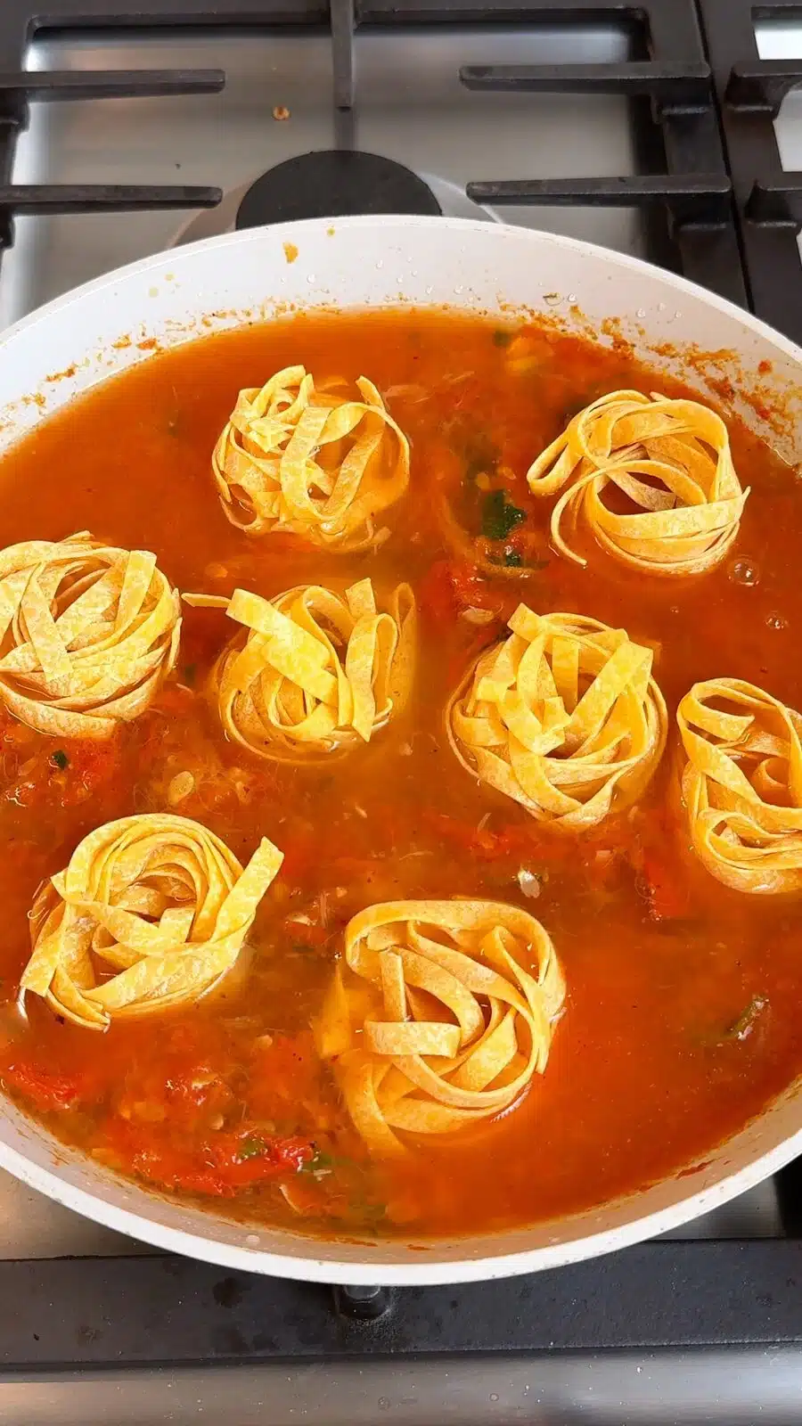 Pasta nests cooking in the tomato and zucchini sauce