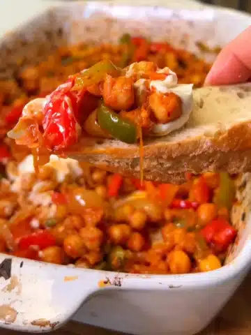 Mediterranean chickpea and pepper bake scooped onto crusty bread