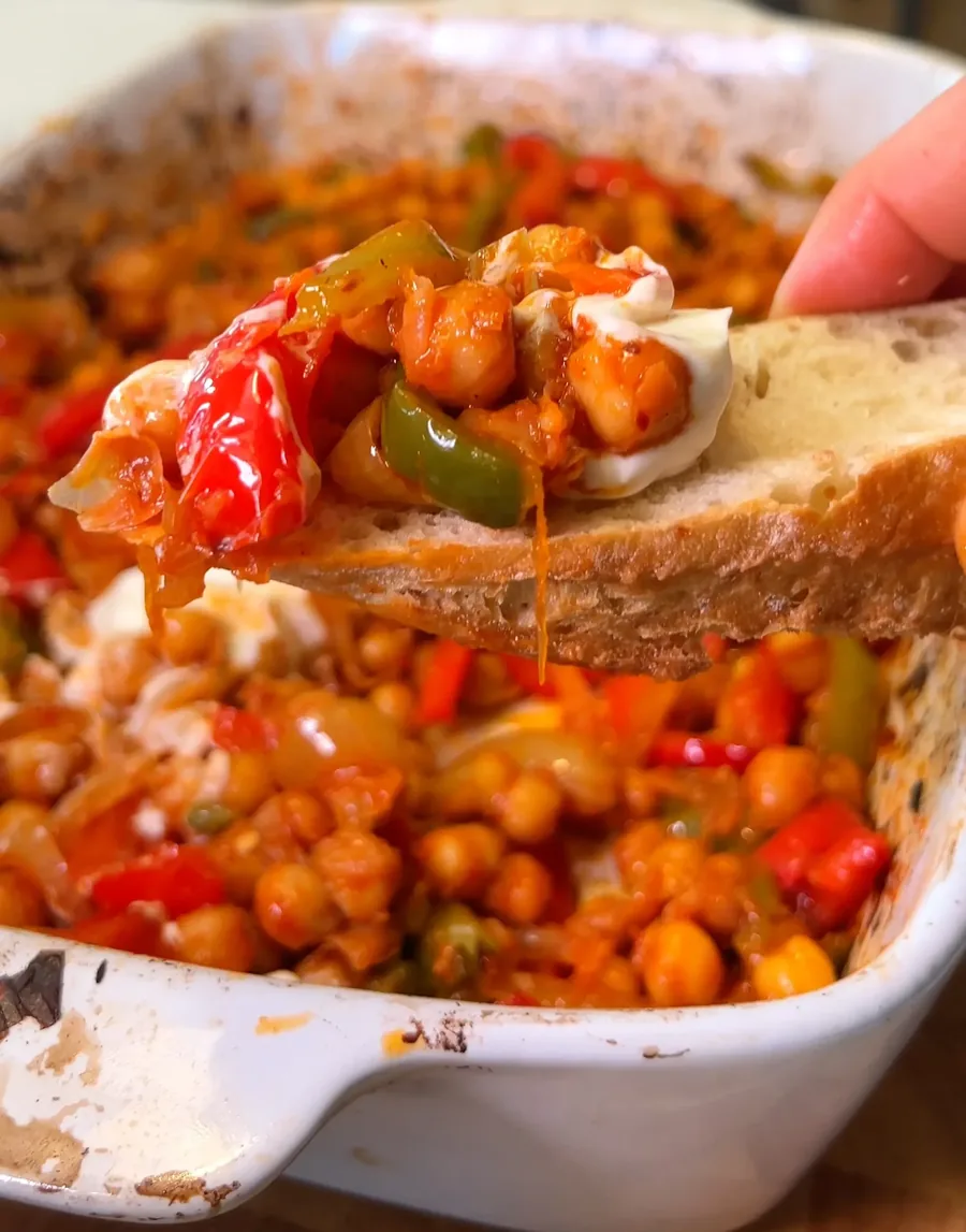 Mediterranean chickpea and pepper bake scooped onto crusty bread