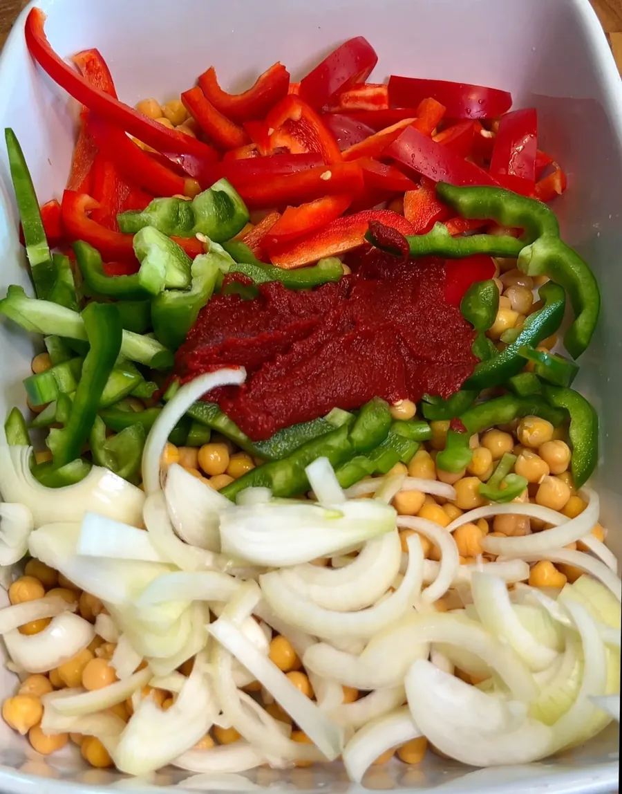 Chickpeas, peppers, onion, and tomato paste in the baking dish