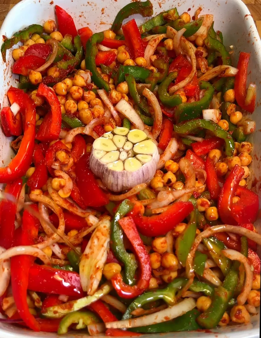 Half a garlic bulb nestled in the middle of the chickpea and pepper bake