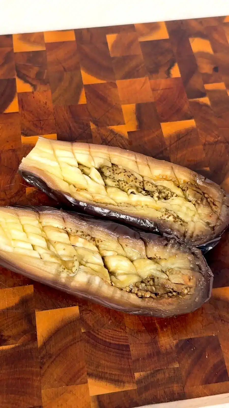 Steamed eggplant halved and scored in a fine crosshatch